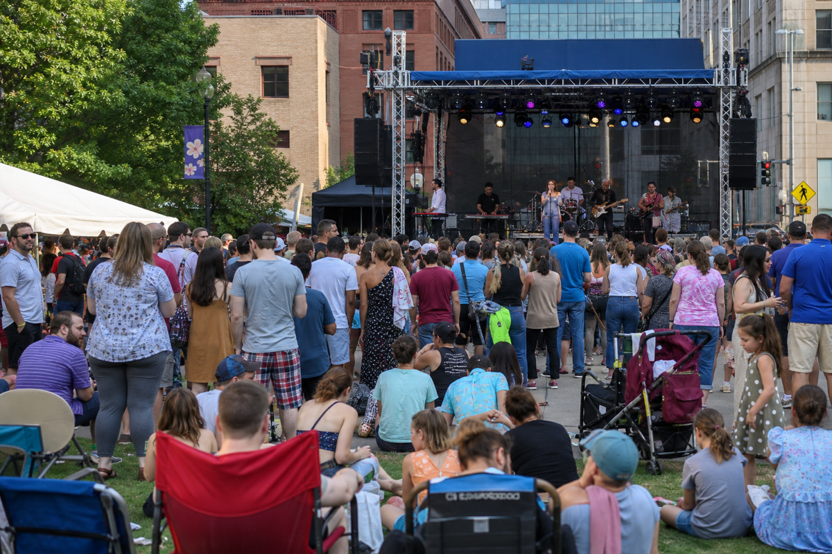 Crowd at a large outdoor community music festival in a city